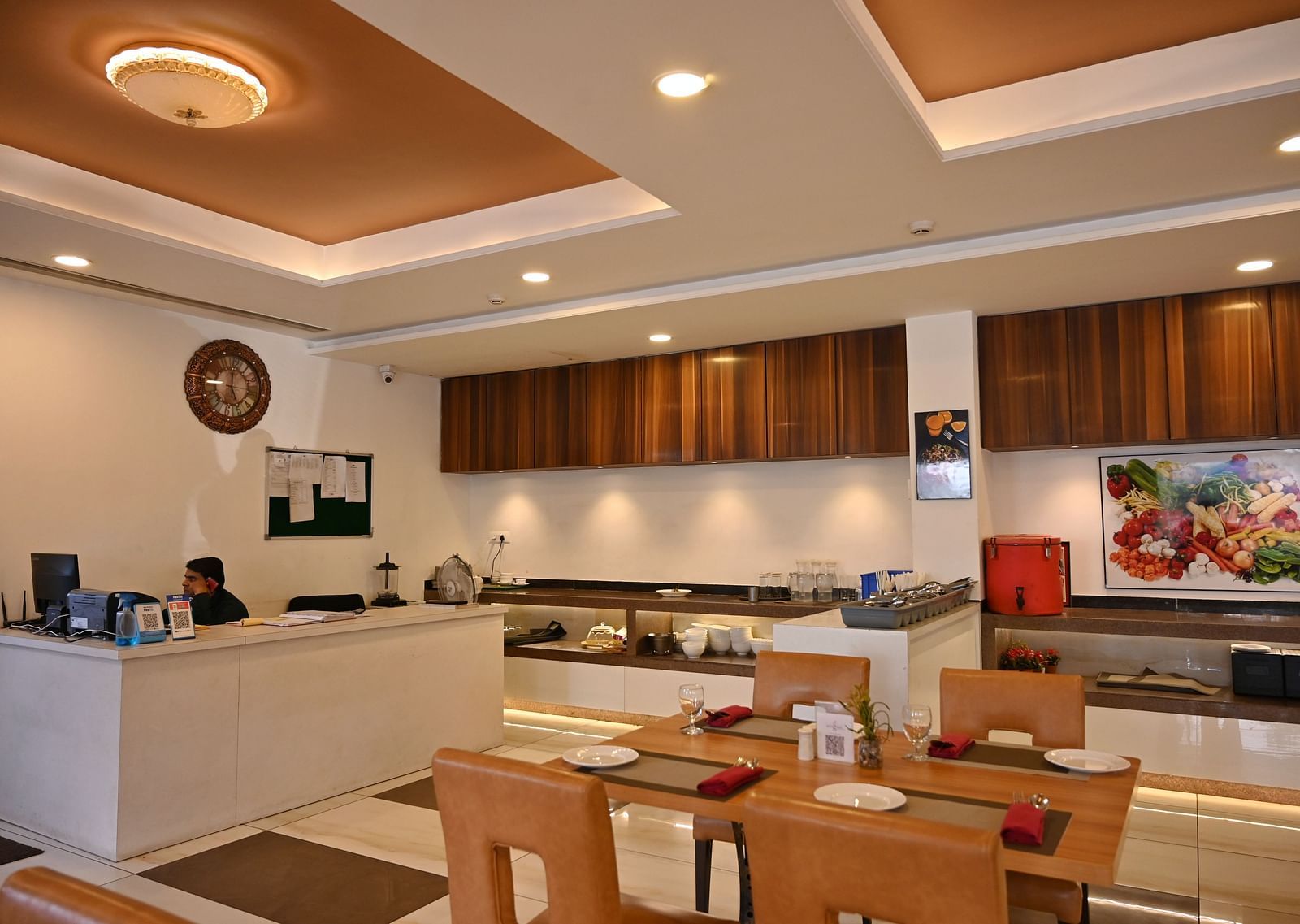A hotel restaurant with tables set for dining and a service counter in the background - TGI Insignia, Bhopal