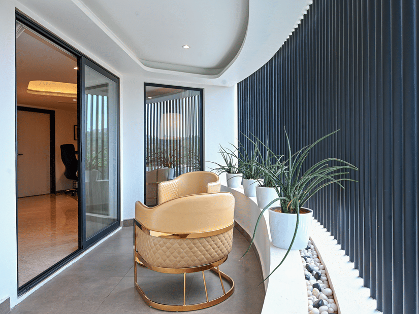 Suite seating nook with elegant gold accent chairs and lush greenery at Dimora Hotels and Resorts, offering a stylish and inviting corner.