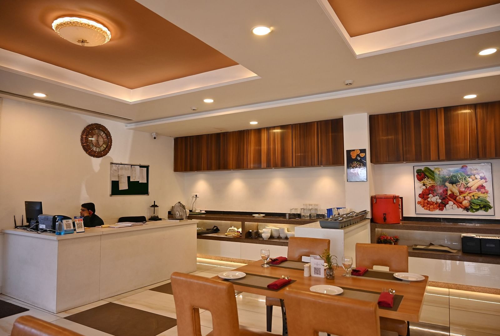 A hotel restaurant with tables set for dining and a service counter in the background - TGI Insignia, Bhopal