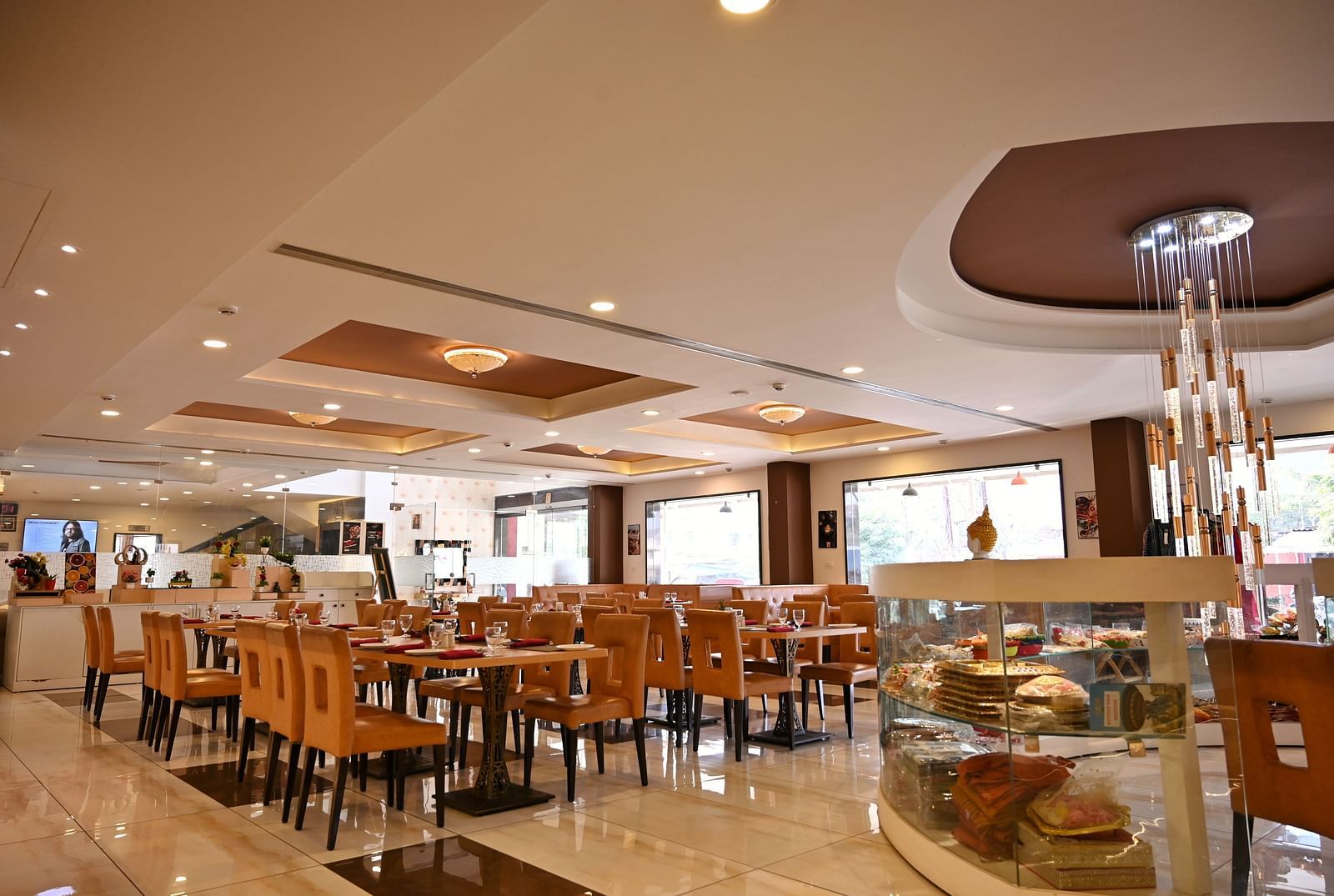 Hotel dining area with neatly arranged tables, contemporary art and a service counter - TGI Insignia, Bhopal