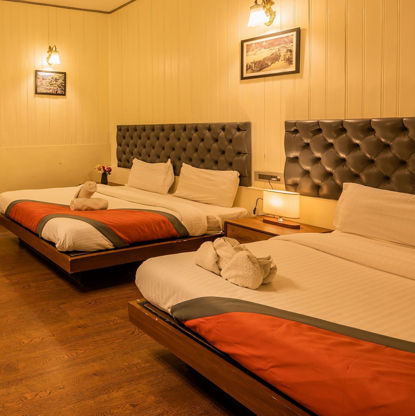 A side corner view of  spacious family room with 2 comfy beds, table, chimney at Arcadia Heritage Resort, Darjeeling