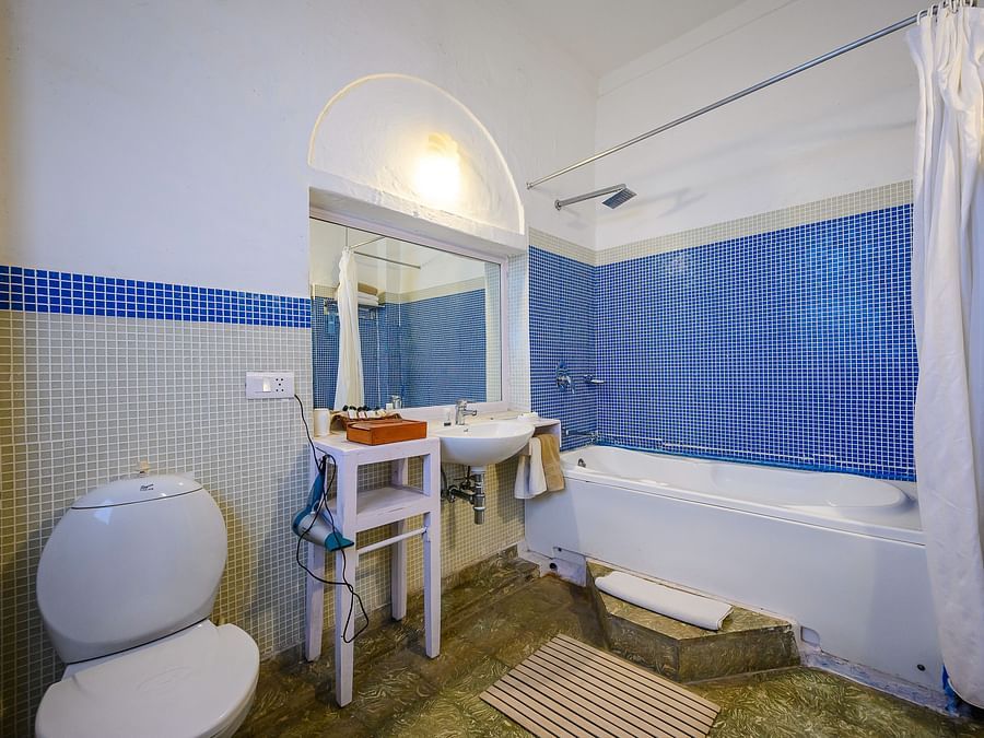 Hill Fort Kesroli 14th Century Alwar - interior view of the Hindola Mahal - Countryside View Washroom with blue interiors, a commode and a bathtub