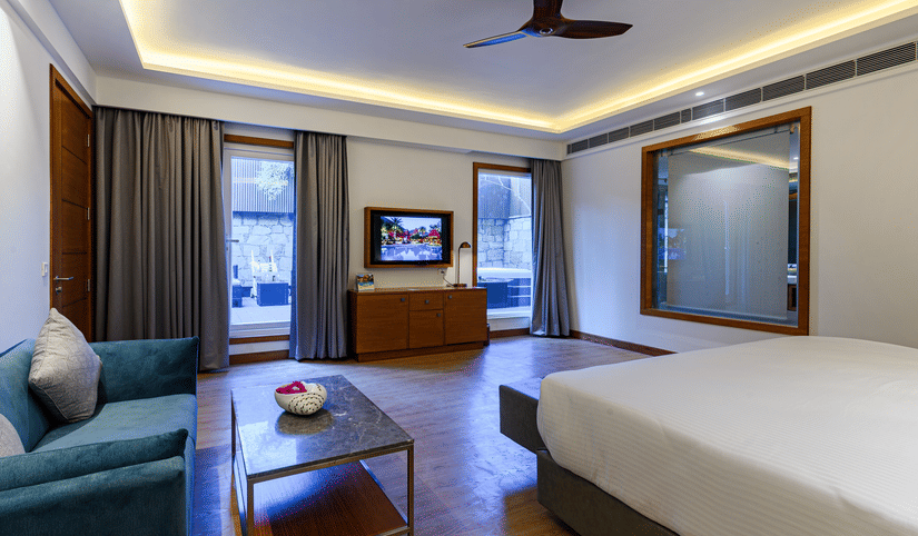 Interiors of one of the bedrooms at our presidential suite in Pushkar featuring a bed, a blue sofa and other furniture 57