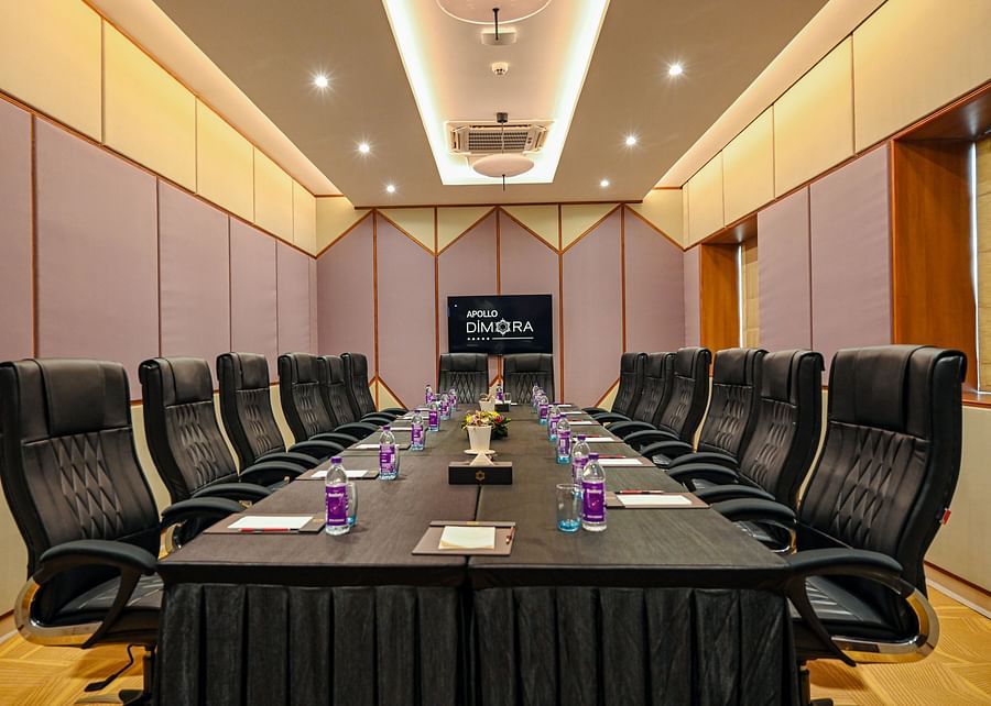 alt-text black coloured seats and a large table offered at the boardroom 