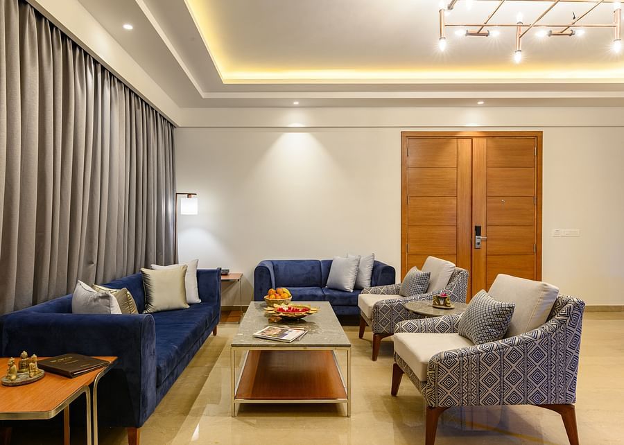 The living room of our Presidential Suites in Pushkar with  a sofa set, a television and a large window PS-4243