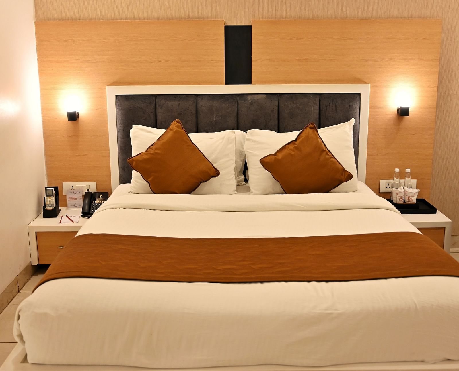 A contemporary bedroom with a plush headboard and coordinated brown accent pillows - TGI Insignia, Bhopal