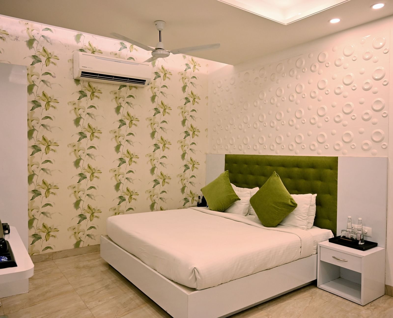 A chic bedroom with a patterned feature wall, modern decor and a green velvet headboard - TGI Insignia, Bhopal