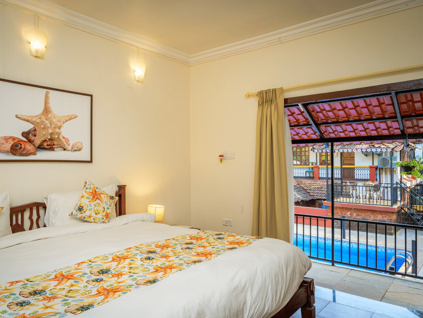 A hotel room in South Goa with a double view and a balcony that opens onto a pool - Neemranas Three Waters