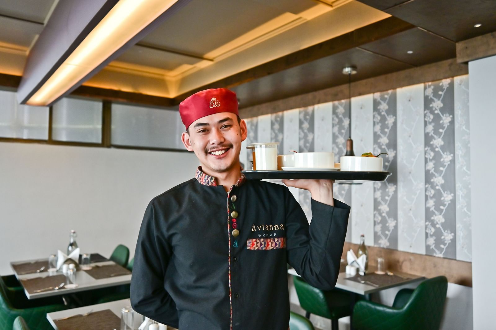 Image of a man holding a tray of food at The Soma Hotel by Avianna Group, Darjeeling