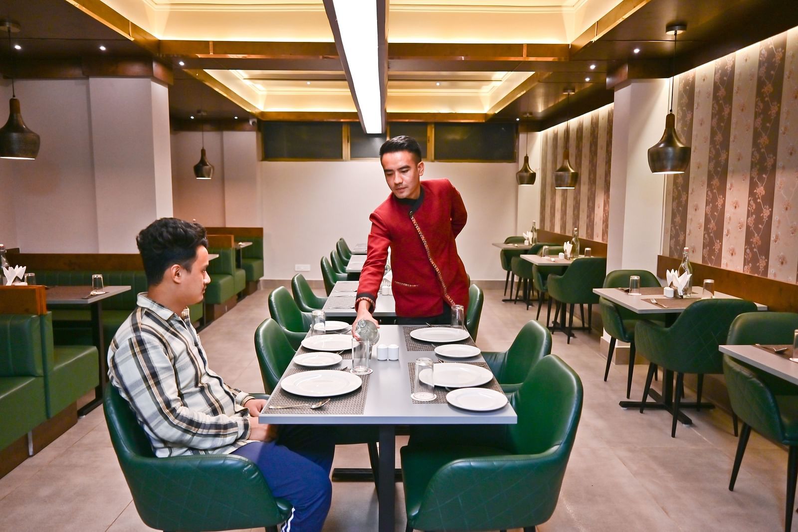 The waiter attending to guests in the restaurant at The Soma Hotel by Avianna Group, Darjeeling