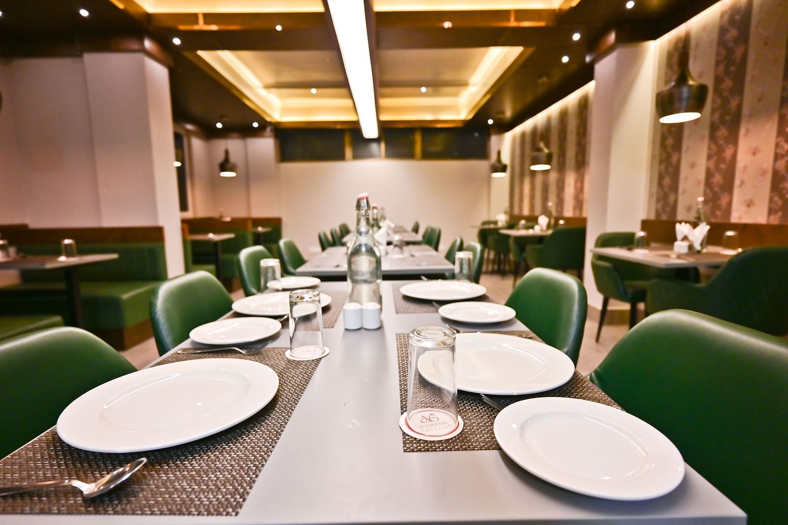 A spacious restaurant with wooden tables and chairs, featuring neatly arranged culinary delights on the tables at The Soma Hotel by Avianna Group, Darjeeling