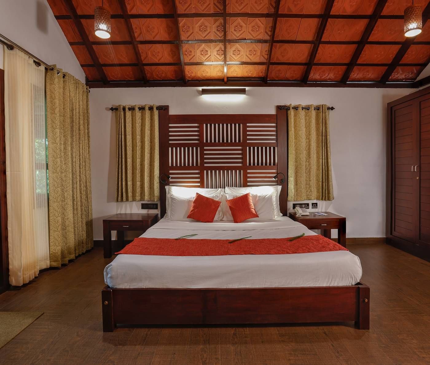 A front view of a bed placed in a room | Vythiri Resort, Wayanad