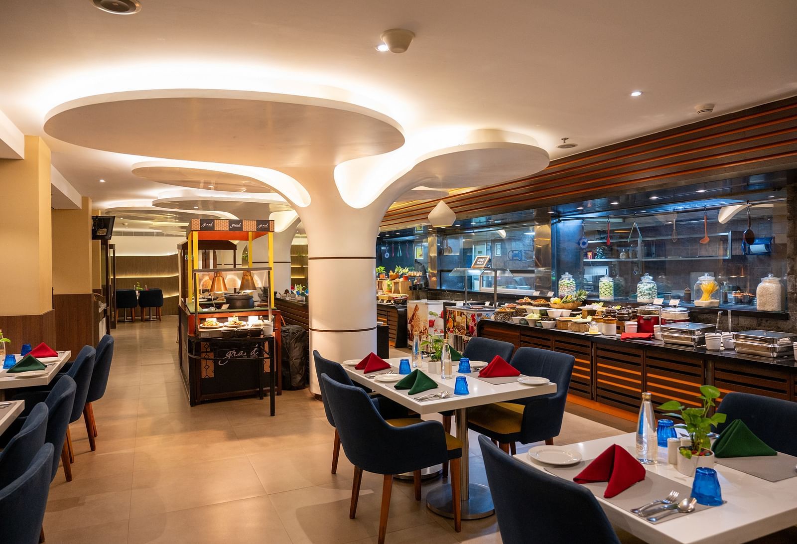 An image of dining space with tables and chairs at Grand Kakinada by GRT Hotels