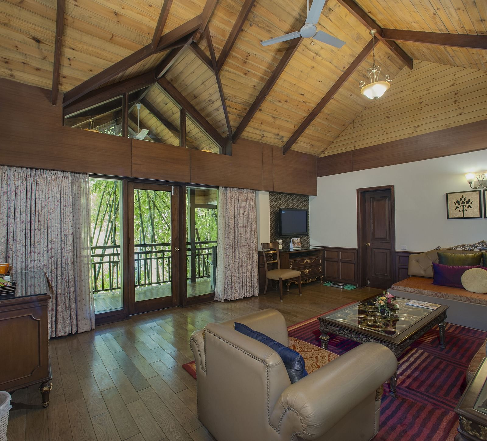 the living room decked with a sofa set and a TV kept above a cabinet - Mayfair Spa Resort & Casino Gangtok