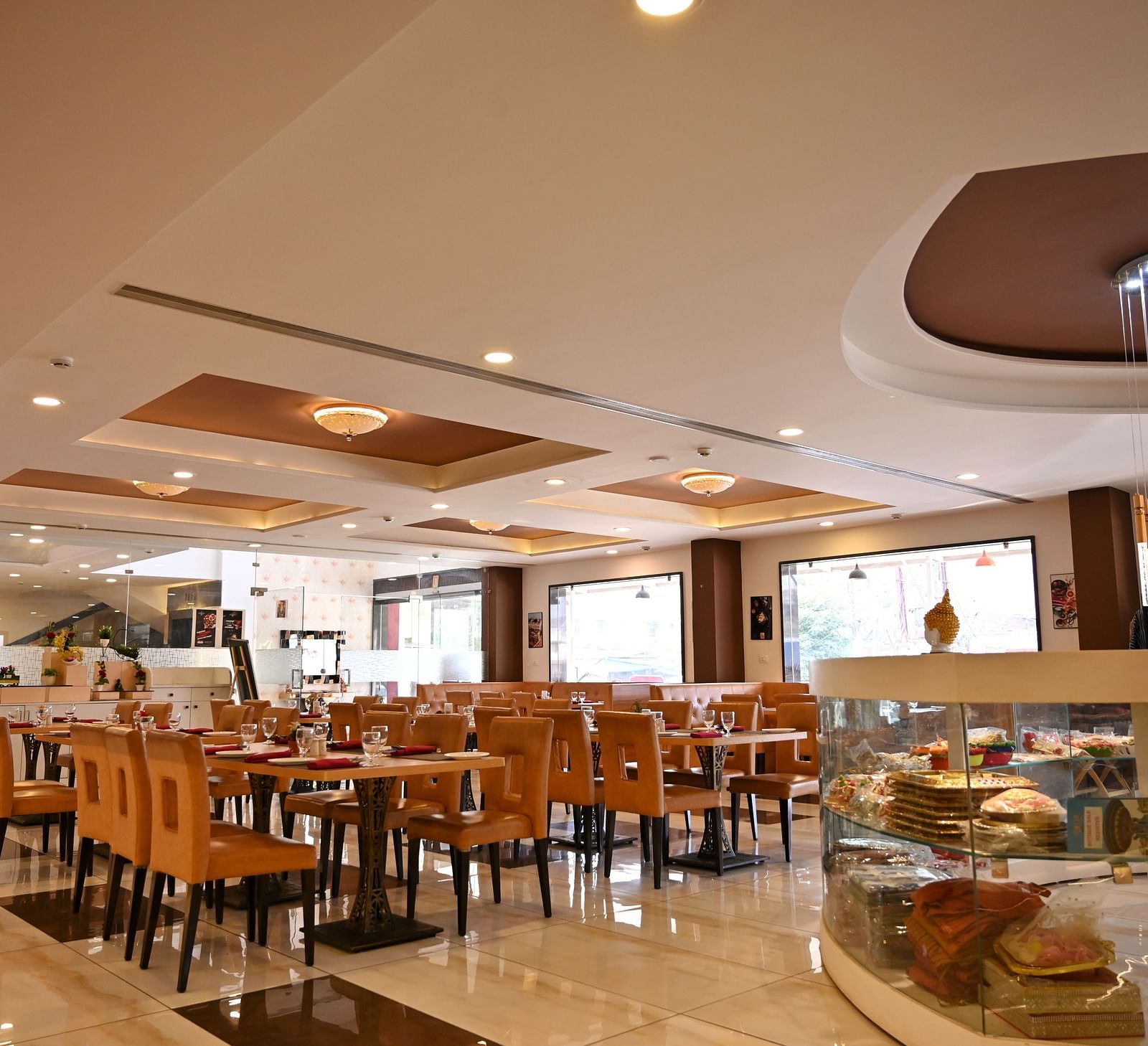 Hotel dining area with neatly arranged tables, contemporary art and a service counter - TGI Insignia, Bhopal