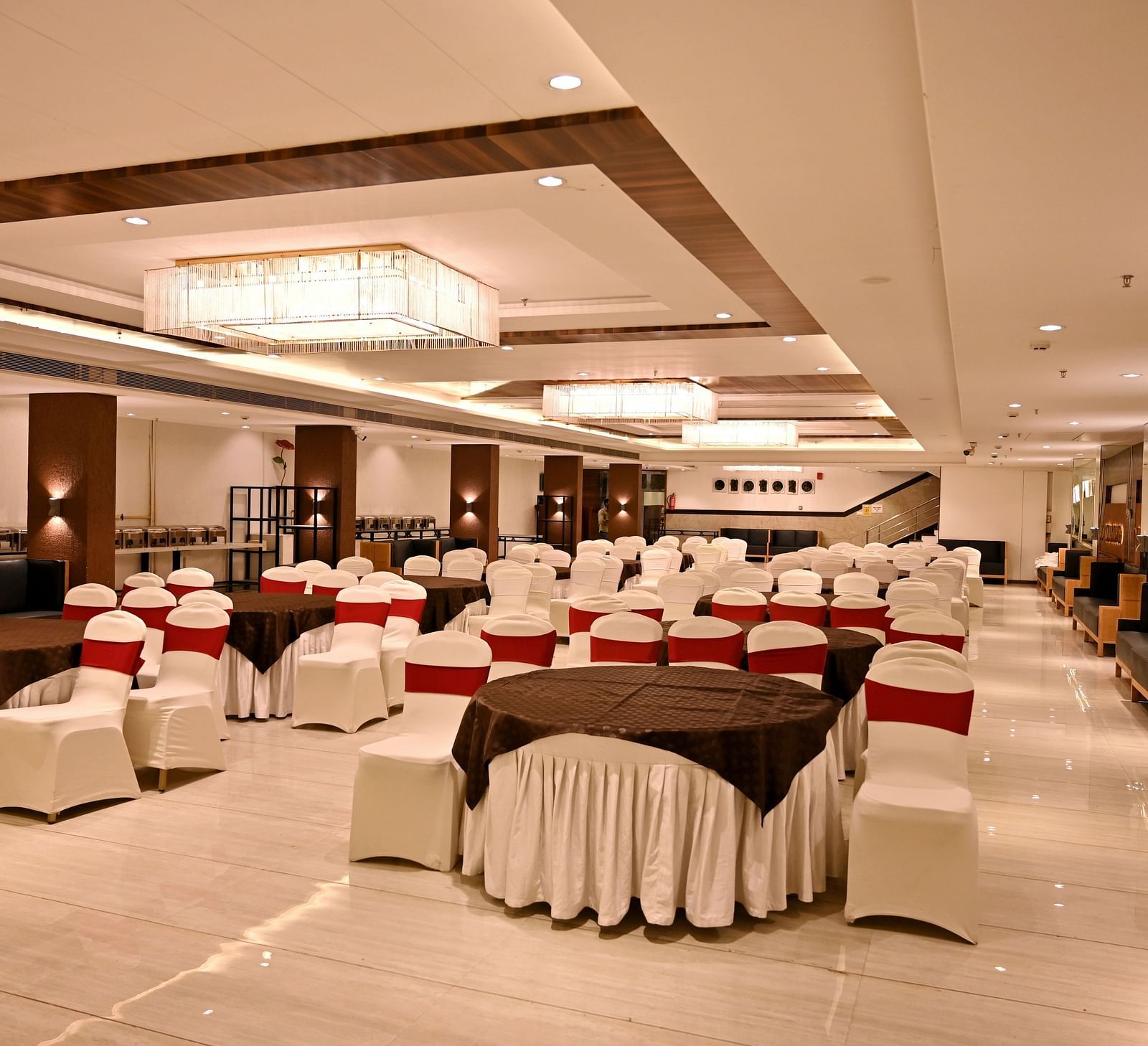 Banquet hall viewed from the end, showcasing the regal chandeliers and polished floors - TGI Insignia, Bhopal