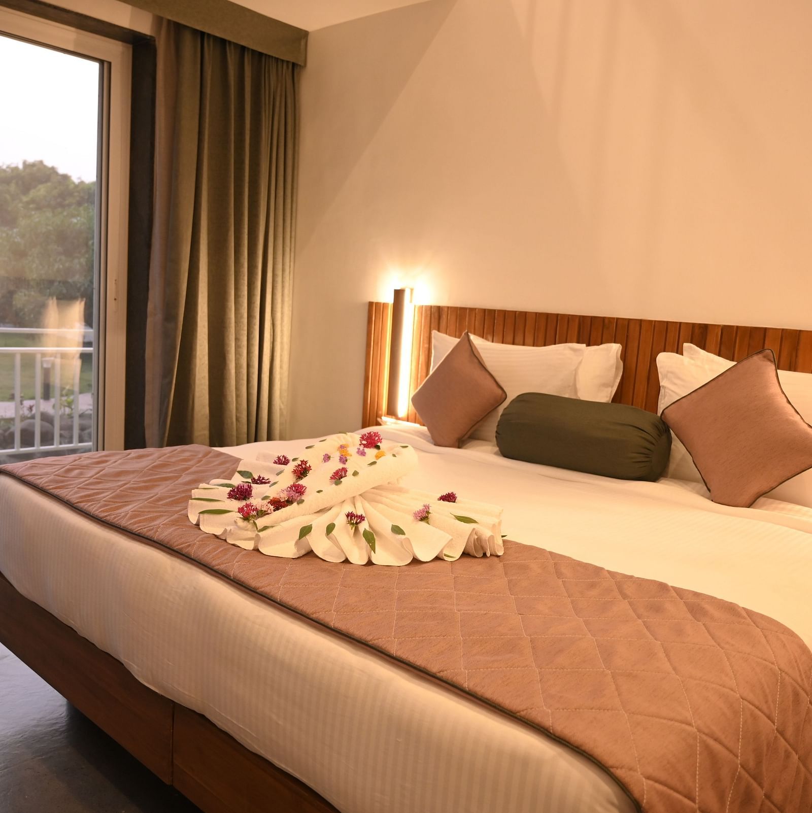 Side view of a double bed at the Kutumbh Suite at Mango Leaf Lake Resort, Pune