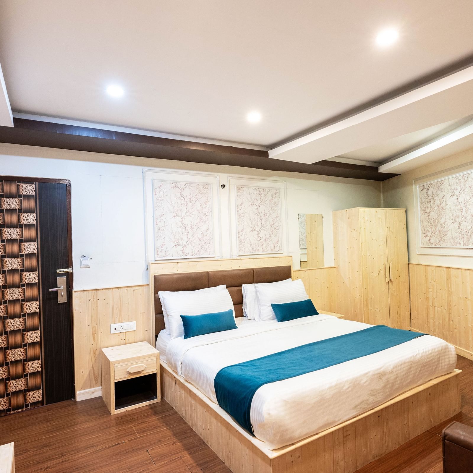 an image of a deluxe room with a wooden wardrobe at an image of a deluxe room with a tea and a coffee maker at Avianna New Mandala Hotel & Spa, Darjeeling
