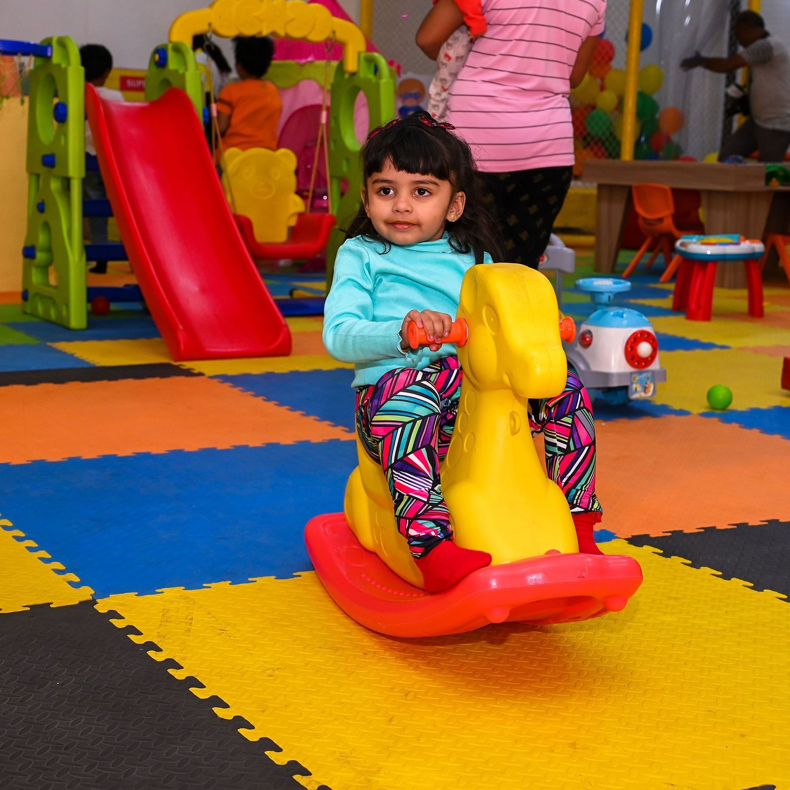 Young child playing on a colorful indoor playground slide | Diamond Parks, Pune