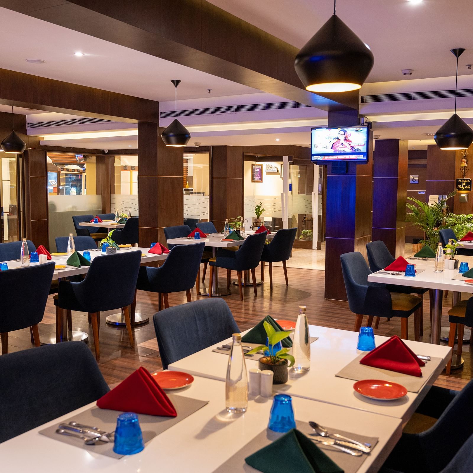 An image of  a dining space with a television  at Grand Kakinada by GRT Hotels