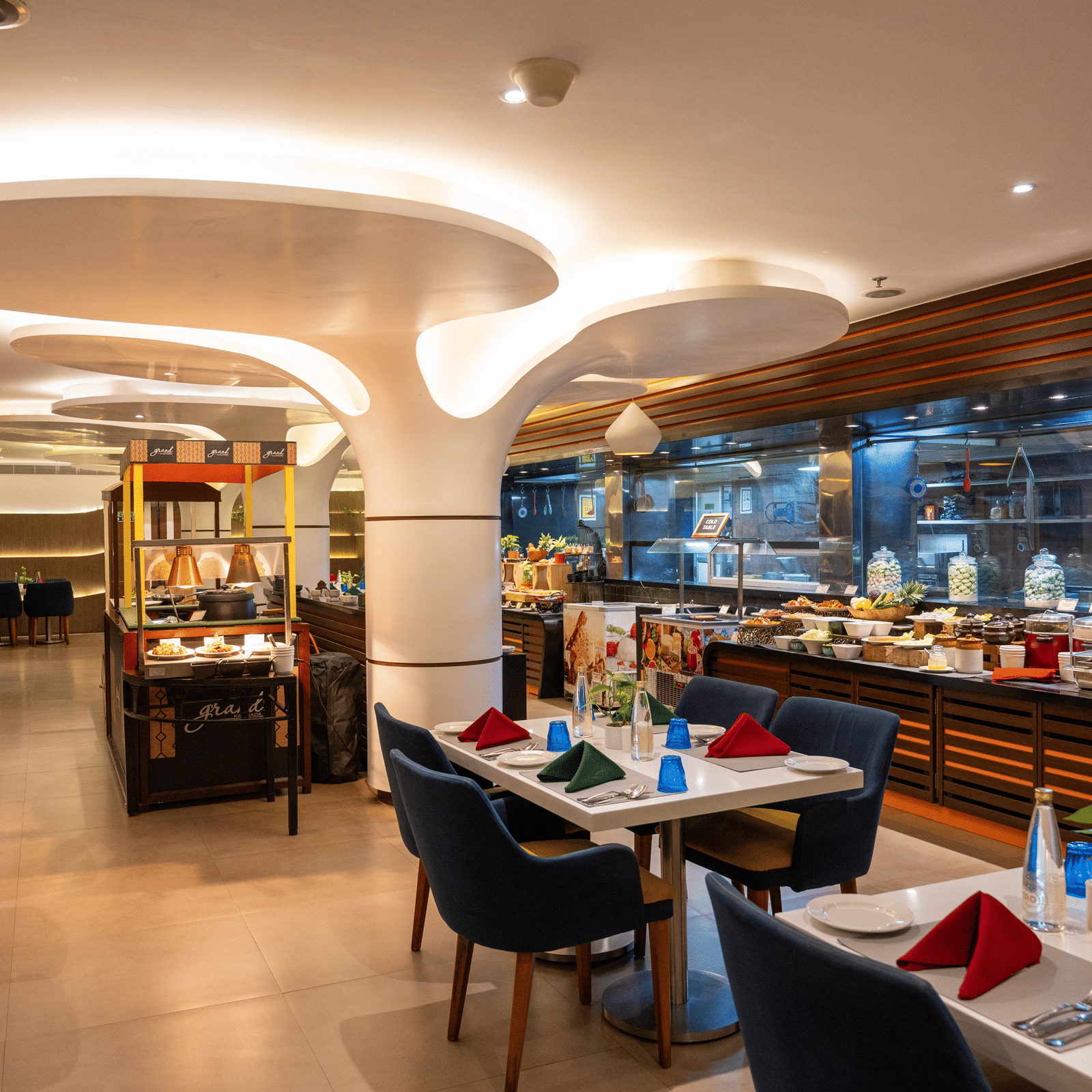 A dining space with tables and chairs at Grand Kakinada by GRT Hotels — a famous restaurant in Kakinada.