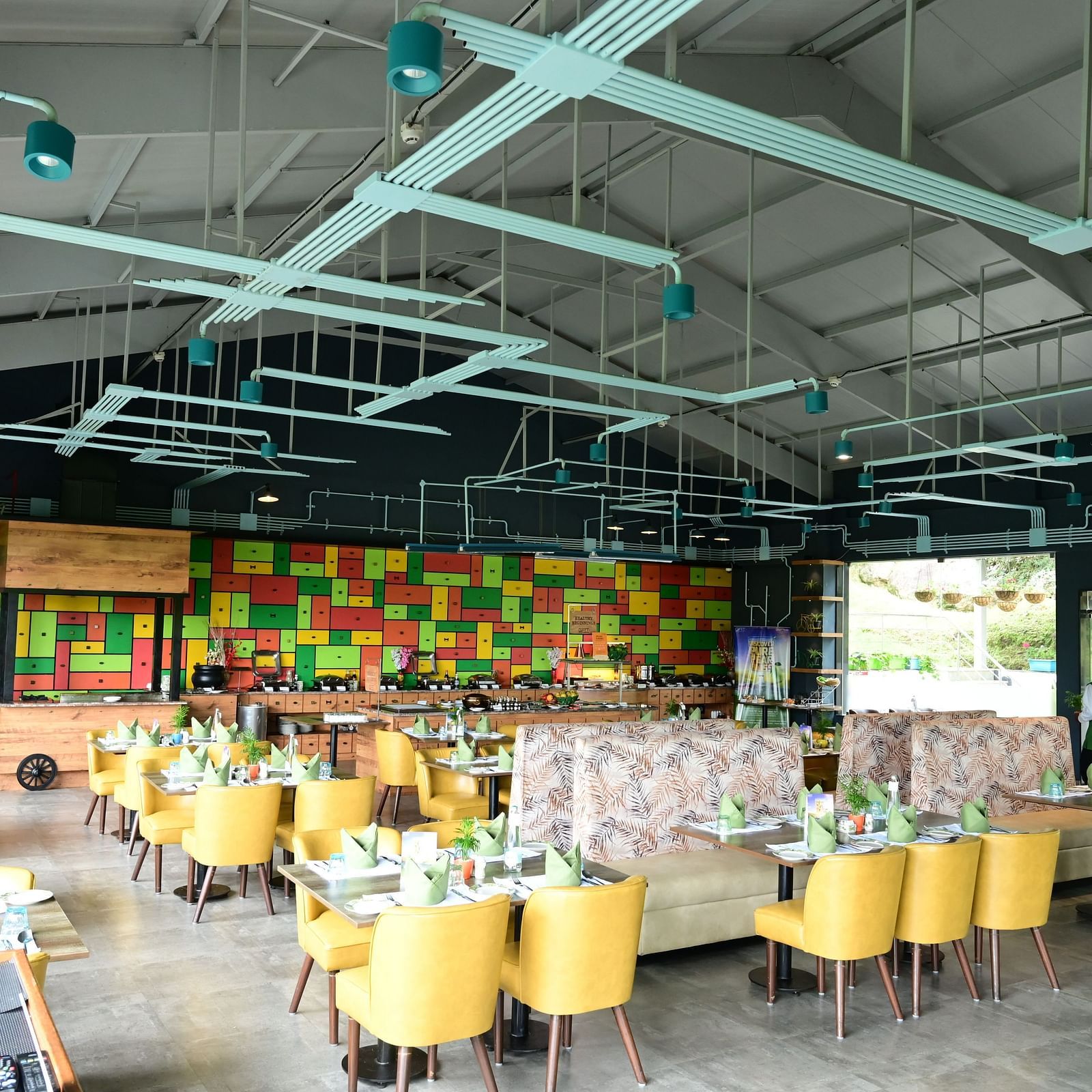 An image of a restaurant with seating arrangement, cutlery, and decorative items - GReaT trails Kodaikanal by GRT Hotels