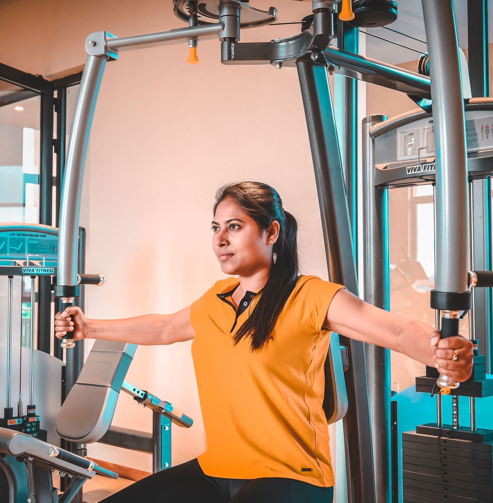 A woman using the chest fly machine in a gym
