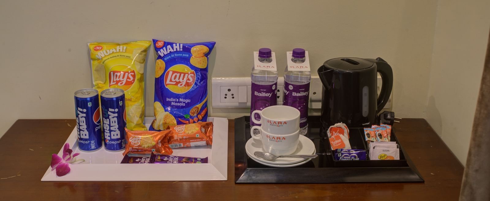 In-room complimentary tea and snack tray with kettle and condiments at Ilara Hotels & Spa, OMR, Chennai