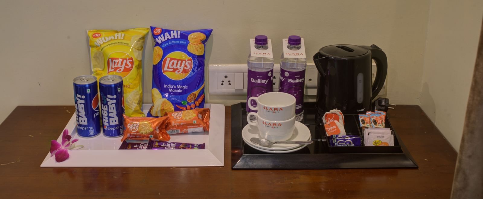 In-room complimentary tea and snack tray with kettle and condiments at Ilara Hotels & Spa, OMR, Chennai