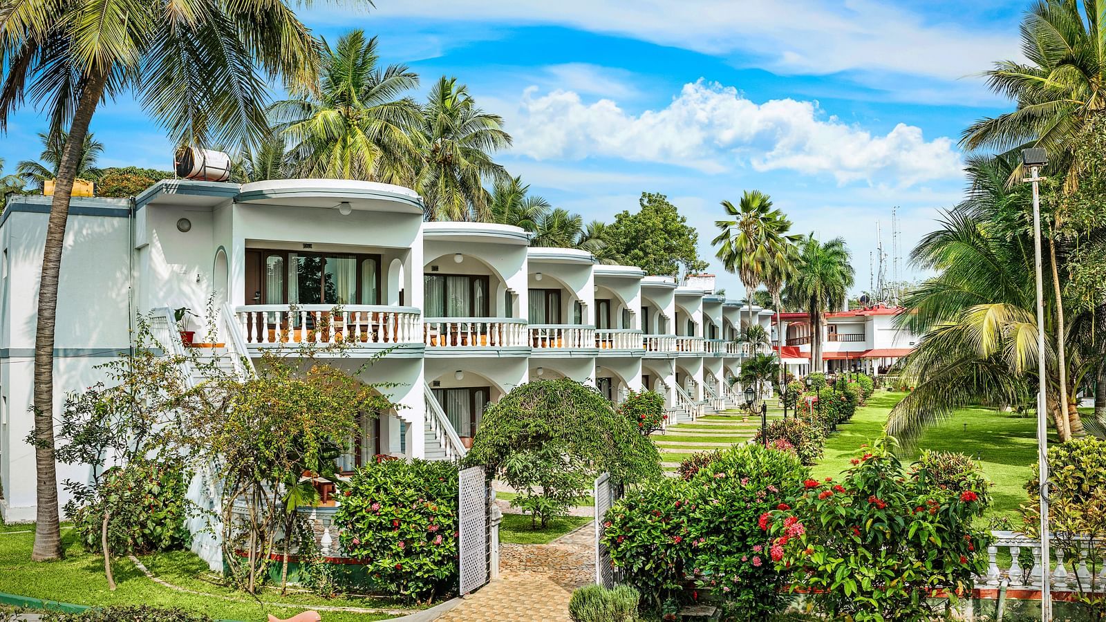 A facade image of a hotel building surrounded by lush greenery - GReaT Trails River View Resort Thanjavur By GRT Hotels