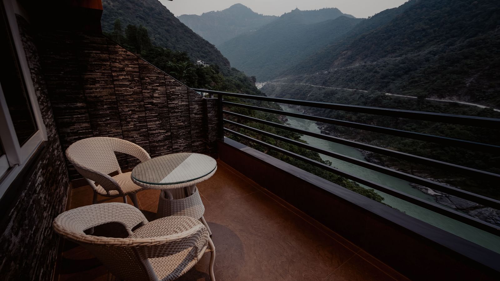 A picturesque view of the mountains and the gently flowing river as seen from the hotel balcony in the soft glow of the evening | The Tattva Devprayag