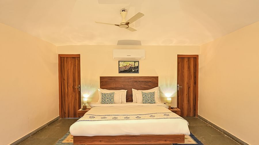 Minimalist bedroom with wooden accents and natural light at Clarks Safari, Jawai.