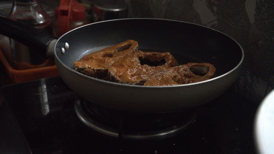 Image of a frying pan with fish in it in the kitchen of  Ananda Holiday Home, Wayanad