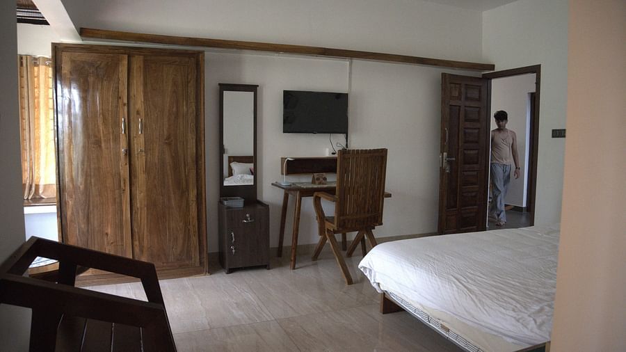 Side view of the Room at Ananda Holiday Home, Wayanad with a TV, a cupboard and a study table