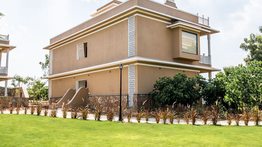 Rear view of a building showcasing an expansive lawn and boundary - Rajbagh Wellness, Udaipur