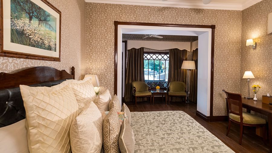 image of the king size bed with the seating area at the far corner of the Club Room at The Claridges Nabha Residence 