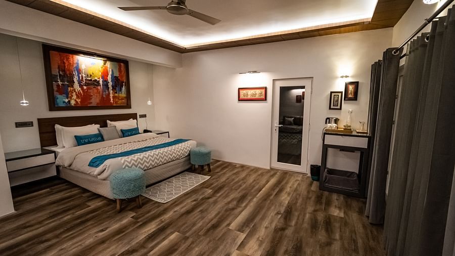 corner view image of the bedroom in the pent house featuring a double bed with modern interiors - The Tattva Boutique Resort