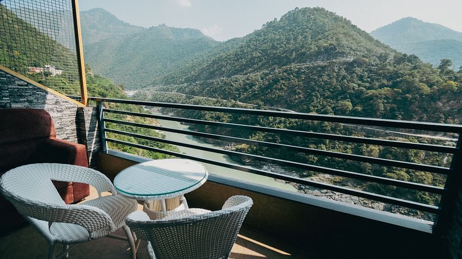 Shot of the mountains and the Ganga from the balcony at the hotel featuring a cosy seating arrangement | The Tattva Devprayag