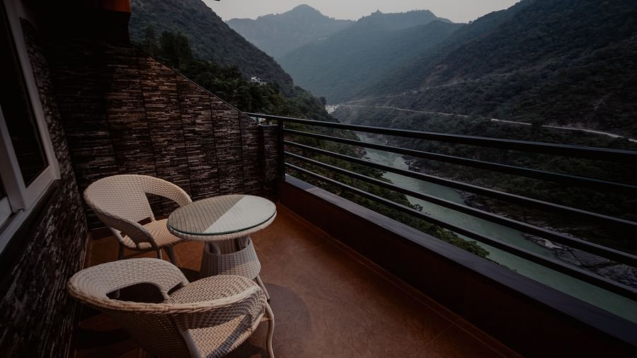 A picturesque view of the mountains and the gently flowing river as seen from the hotel balcony in the soft glow of the evening | The Tattva Devprayag