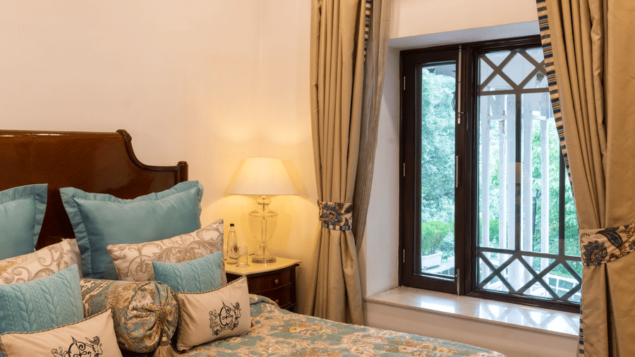 image of the bed and the window with an amzing view besides the bed of the Deluxe room at The Claridges Nabha Residence