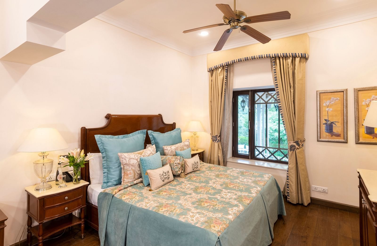 image of the king size bed with sky blue coloured sheets and the window view at the Deluxe Rooms at The Claridges Nabha Residence
