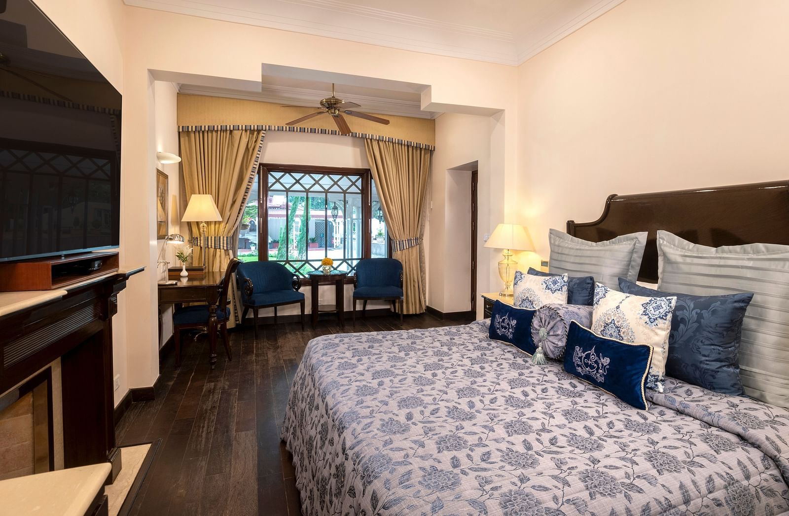 image of a king size bed and the seating area of the Claridges room at The Claridges Nabha Residence