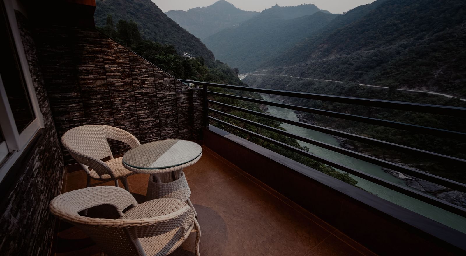 A picturesque view of the mountains and the gently flowing river as seen from the hotel balcony in the soft glow of the evening | The Tattva Devprayag