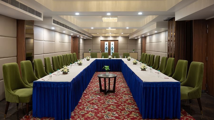  A conference room set up with blue and green chairs around a central table, ready for business meetings and discussions - Clarks Inn Express, Near Jammu Bari Brahmana Railway Station