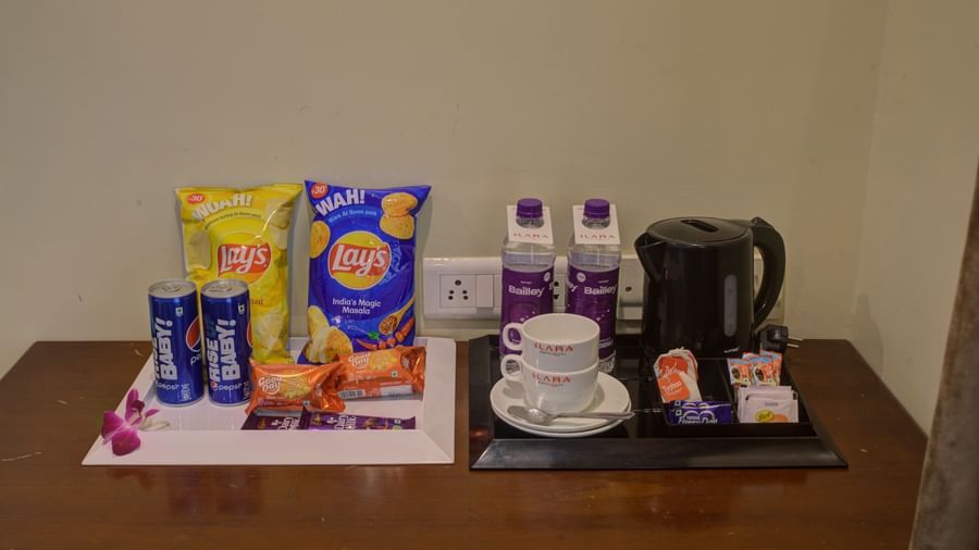 In-room complimentary tea and snack tray with kettle and condiments at Ilara Hotels & Spa, OMR, Chennai