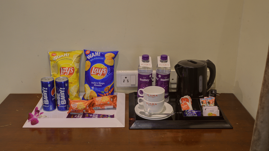 In-room complimentary tea and snack tray with kettle and condiments at Ilara Hotels & Spa, OMR, Chennai