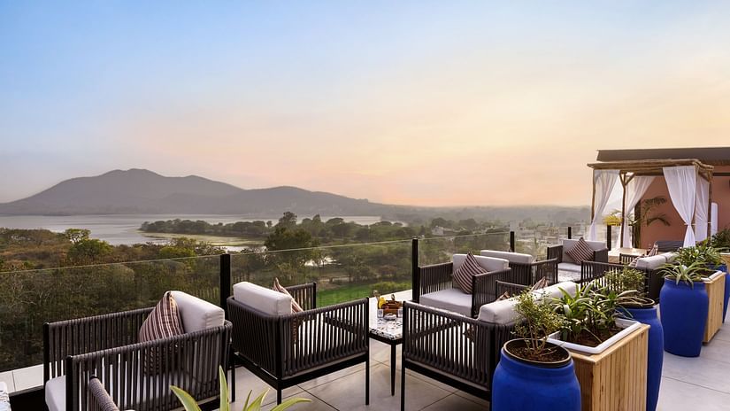 The terrace bathed in soft lights, highlighting comfortable seating and panoramic views.