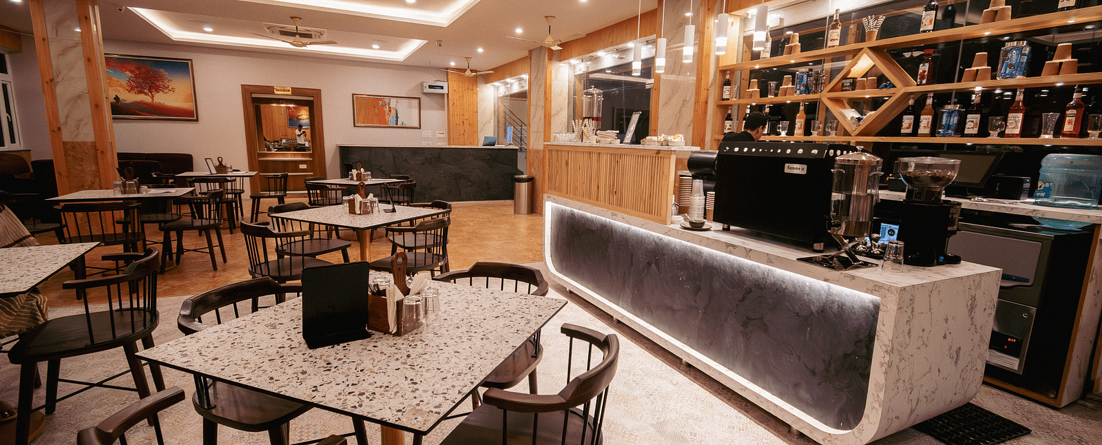 An overview of a restaurant at The Tattva, Devprayag featuring fine dining setup and bar section. - Restaurants in Devprayag