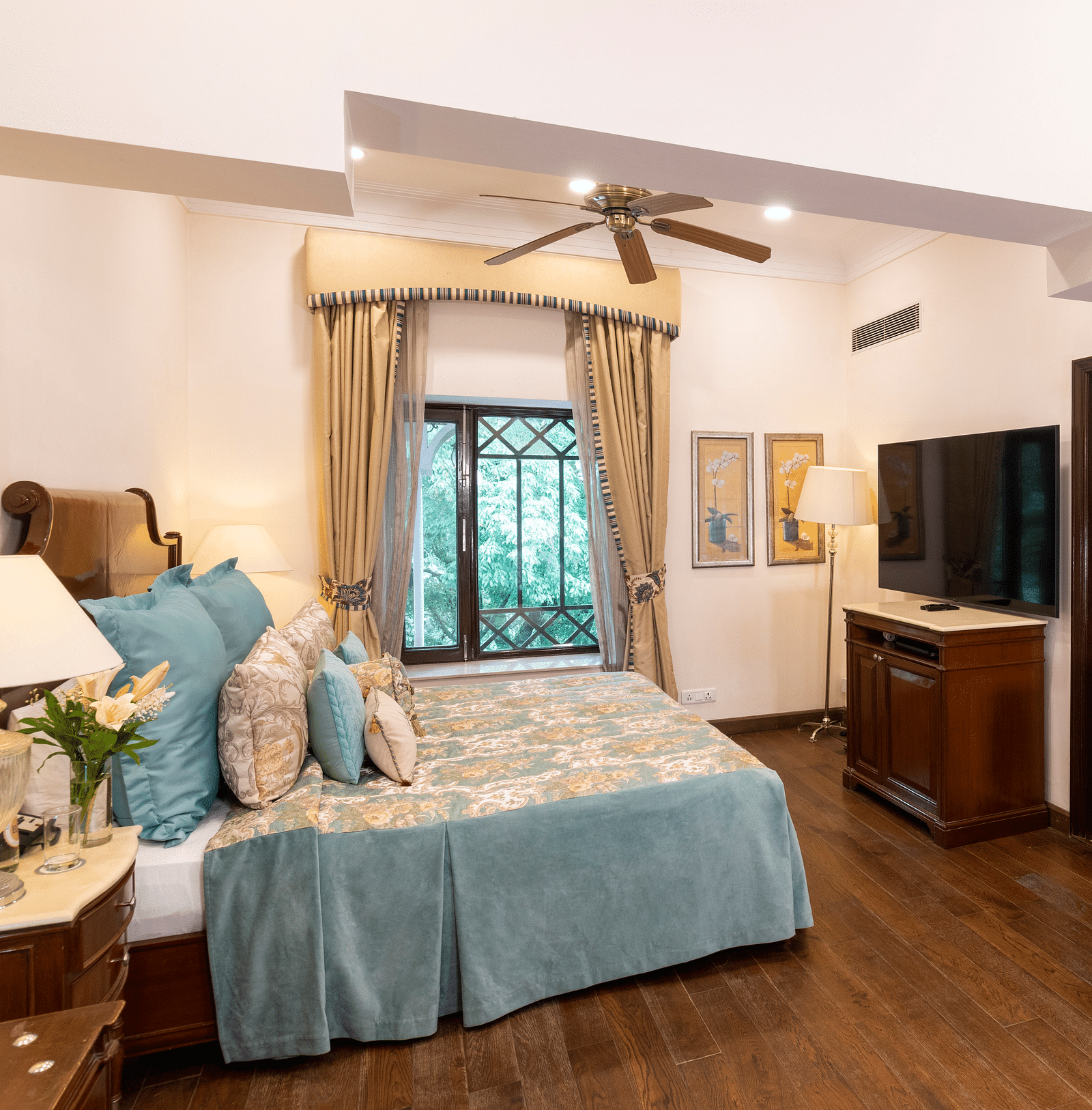 full view of the deluxe room with wooden interiors and a window at the far end at The Claridges Nabha Residence