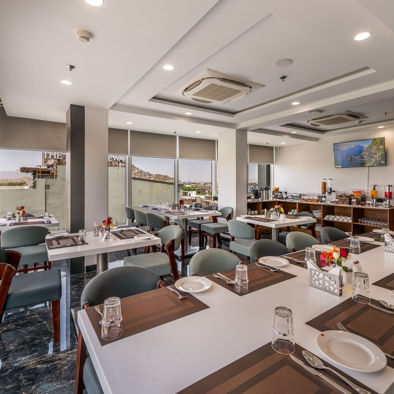 A modern, light-filled BCR restaurant featuring sleek dining tables, cool chairs, and lots of windows.